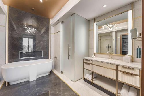 a bathroom with a tub and a large mirror at Hilton Club Elara Las Vegas in Las Vegas