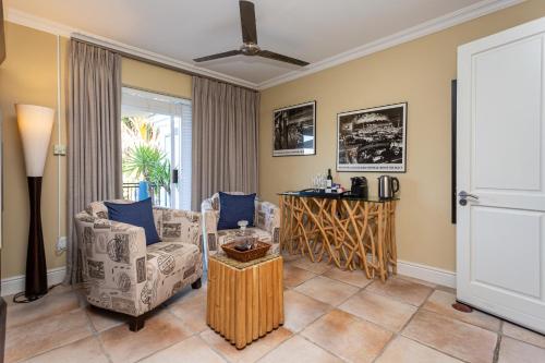 uma sala de estar com duas cadeiras e uma mesa em Pictures Guest House Boutique Hotel em Oudtshoorn