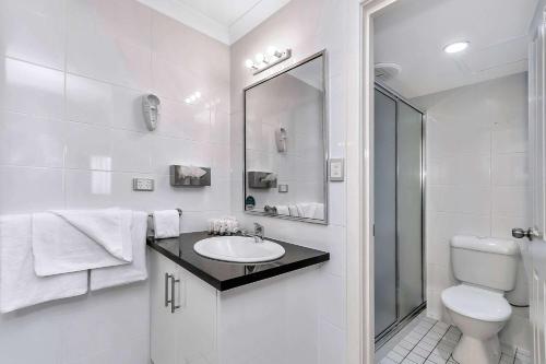 Baño blanco con lavabo y aseo en Quality Inn Railway Motel, en Kalgoorlie