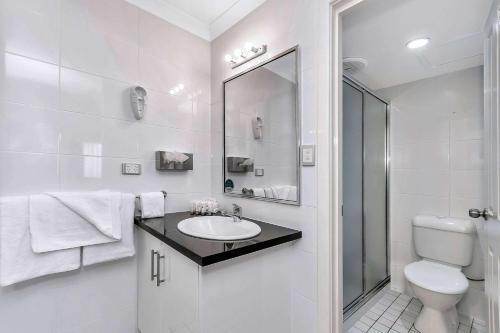 a white bathroom with a sink and a toilet at Quality Inn Railway Motel in Kalgoorlie