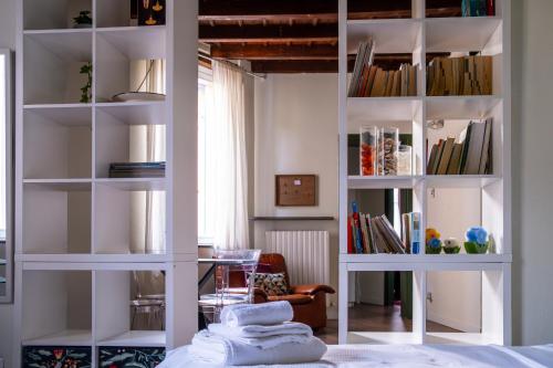 um quarto com prateleiras de livros brancos e uma cama em L'eco della rosa em Crema