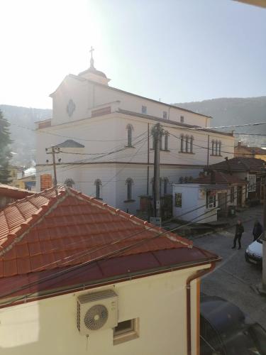 un grand bâtiment blanc avec une horloge. dans l'établissement Apartment DAMJAN - Kruševo, à Kruševo
