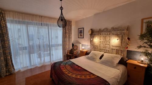 a bedroom with a bed and a large window at Nuances bretonnes in Elliant