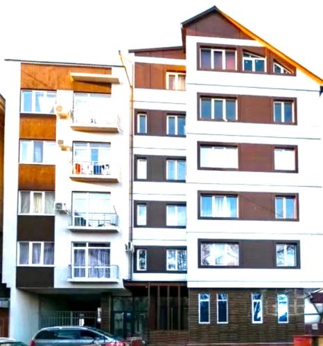 an apartment building with balconies and a car parked in front at Center Apartment in Chişinău