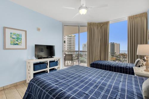 a bedroom with a bed and a tv and a balcony at St. Lucia 704 in Destin