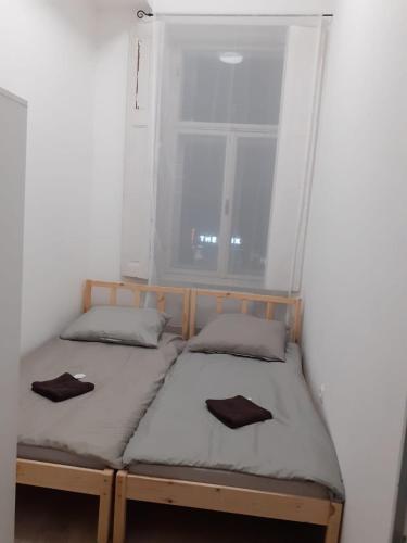 2 Betten in einem Zimmer mit Fenster in der Unterkunft Fantomas*** City Center Apartments No2 3Bedroom + Living room in Szombathely
