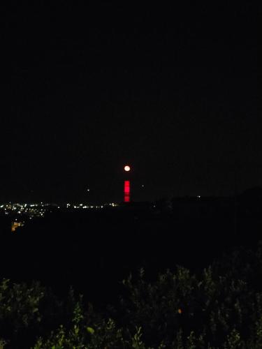 a red lighthouse at night with a red light at Il Limoneto di Leo in Mascali