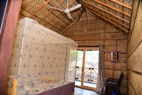 een kamer met een bed in een strohut bij Sunny Guest House Hampi in Hampi