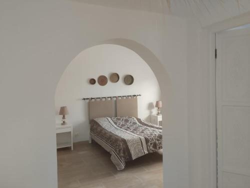 ein Schlafzimmer mit einem Bett in einem weißen Zimmer in der Unterkunft Duplex Hammamet in Hammamet
