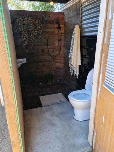 a bathroom with a toilet in a shed at Sanctuary Cabin in Sanctuary Point