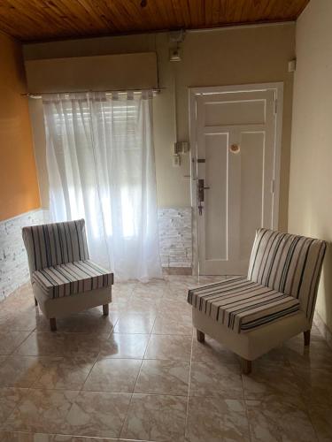 dwa krzesła i ławka w salonie w obiekcie Balcarce 3842 w mieście Olavarría