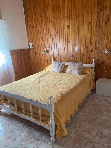 Cama en habitación con pared de madera en Balcarce 3842 en Olavarría