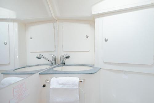 uma casa de banho com um lavatório e 2 janelas em Stay in a Boat - Algarve (Blue Pearl) em Albufeira
