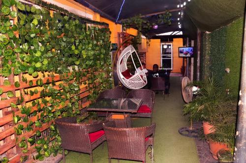a restaurant with a wall of plants and tables and chairs at Trending Place Hotel and Suites in Lagos