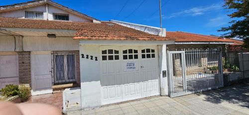 una casa con puertas blancas y una puerta en La casa chiquita en Mar del Plata