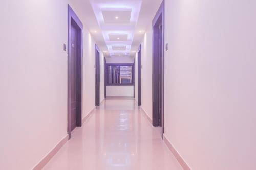 un pasillo de un edificio con paredes blancas y puertas negras en Hotel Hirak Inn, en Dhanbād