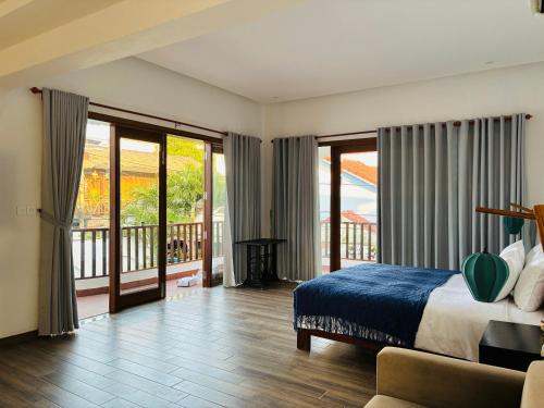 a bedroom with a bed and a balcony with sliding glass doors at Soleil de An Bang Villa in An Bang