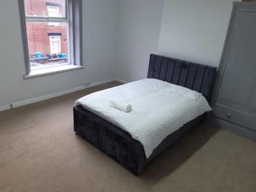 a bedroom with a bed with a white pillow on it at Cozy large double RM 10 in Oldham