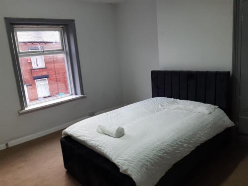 a bed in a bedroom with a window at Cozy large double RM 10 in Oldham