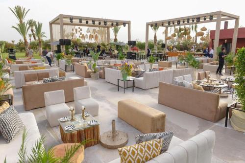 a restaurant with white couches and tables and people at DAR NOUJOUM in Marrakech