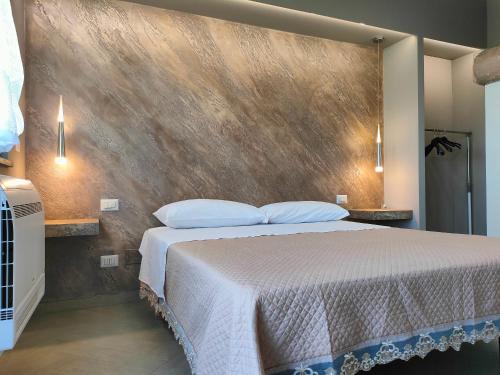 a bedroom with a large bed and a wall at Il Limoneto di Leo in Mascali