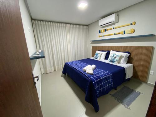 a bedroom with a bed with a teddy bear on it at Apt. Ah-Mar in Porto Seguro