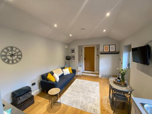 a living room with a blue couch and a table at The Annexe in Middleham