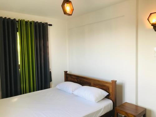 um quarto com uma cama e uma cortina verde em Star Beach Villa em Tangalle
