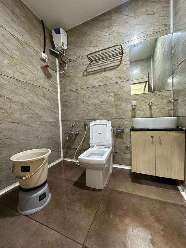 a bathroom with a toilet and a sink at HOTEL ATITHI INN in Vadodara