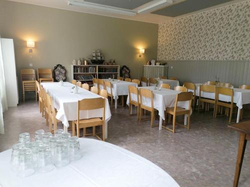 a dining room with white tables and chairs at Villa Puharila in Längelmäki