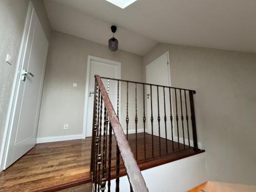 a staircase in a house with a wooden railing at Mazurskie Siedlisko Langen in Mrągowo