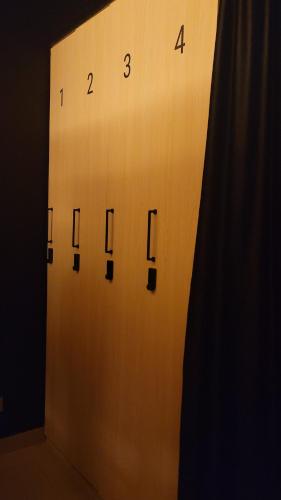 een houten deur met een klok aan de muur bij WeStay Budget Hostel in Dubai