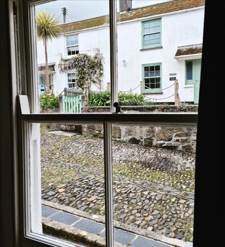 an open window with a view of a house at Sea Shanty Cottage in Newlyn
