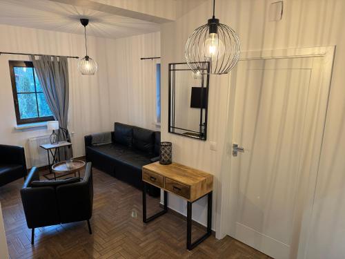 姆龍戈沃的住宿－Mazurskie Siedlisko Langen，客厅配有黑色沙发和桌子