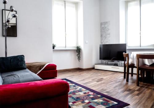 un soggiorno con divano rosso e TV a schermo piatto di Suite Mont Blanc nel Cuore di Torino a Torino