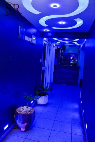 a blue room with a hallway with potted plants at Selella Resort in Kisumu