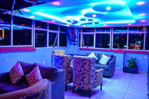 a bar with blue lights and purple chairs at Selella Resort in Kisumu