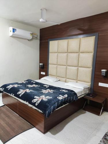 - une chambre avec un grand lit et une tête de lit en bois dans l'établissement SETIA HOTEL, à Malaut