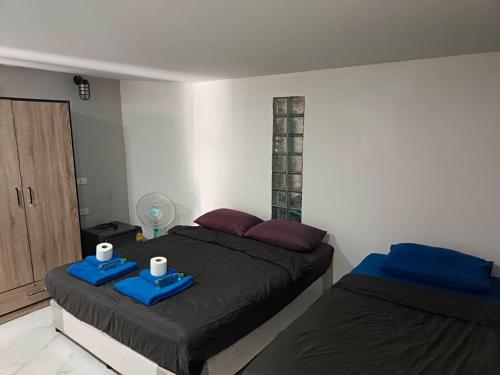 a bedroom with two beds with blue trays on them at MediLeaf Hostel in Haad Rin