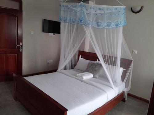 a bedroom with a bed with a canopy at SEED HOTEL in Entebbe
