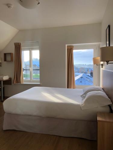 ユセルにあるLe Grand Hôtel Ussel ''nouvelle Gérance 2023''のベッドルーム(大きな白いベッド1台、窓付)