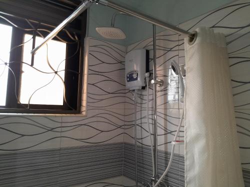 a shower with a shower curtain in a bathroom at SEED HOTEL in Entebbe