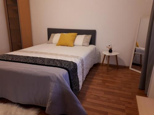 a bedroom with a bed with a yellow pillow at Sunny Cozy Apartament Floreasca in Bucharest