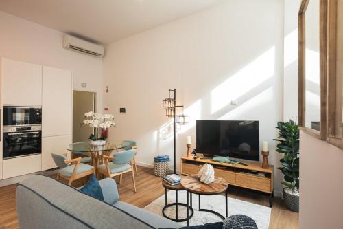 a living room with a couch and a tv at Varanda Azul - First Mate Loft (City Centre) in Ponta Delgada