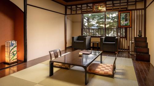 a living room with a table and chairs at Katakurinohana in Senboku