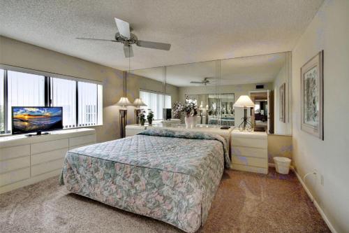 ein Schlafzimmer mit einem großen Bett und einem großen Spiegel in der Unterkunft Land's End 3-406 Bay Front in St Pete Beach