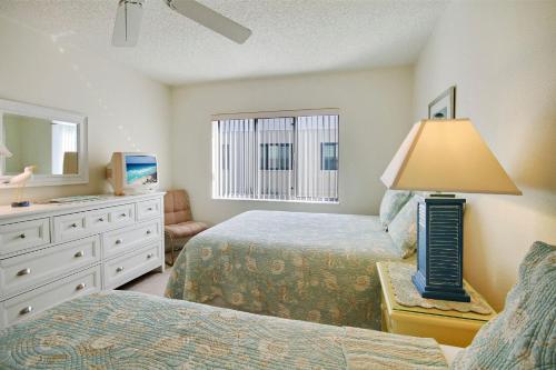 a bedroom with two beds and a table with a lamp at Land's End 8-401 Beach Front in St Pete Beach