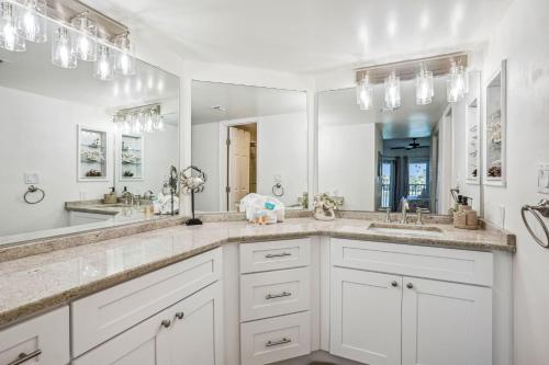 a bathroom with two sinks and a large mirror at Land's End 3-205 Bay Front - Premier in St. Pete Beach