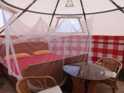 um quarto com uma cama e uma mesa numa tenda em Jurten im Garten Eden BUB em Gützkow