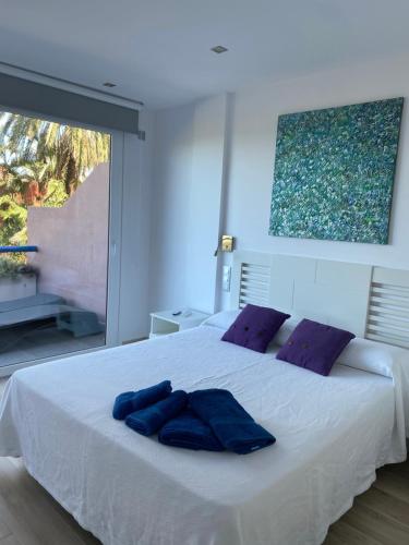 a bedroom with a white bed with purple pillows at Vivienda vacacional “Punta de la arena” in Breña Baja